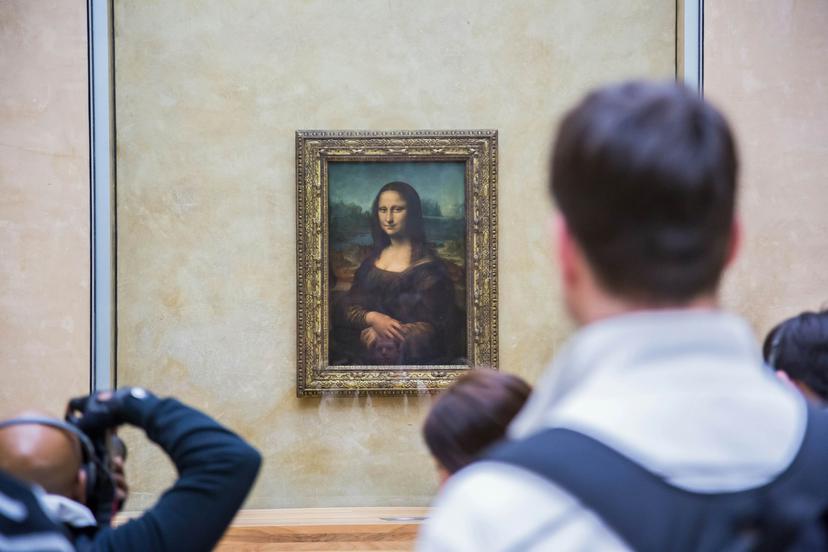 PARIS - AUGUST 4: Visitors take photo of Leonardo DaVinci's "Mona Lisa" at the Louvre Museum, August 4, 2012 in Paris, France. The painting is one of the world's most famous.