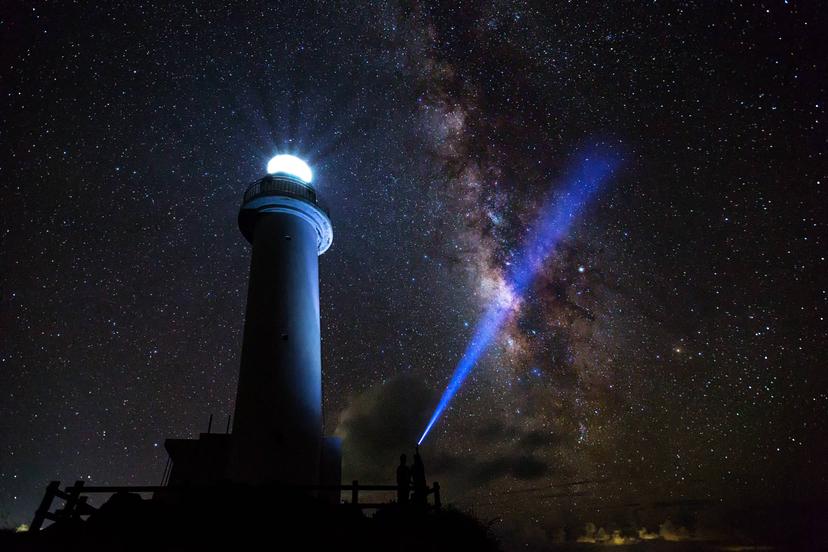 The Milky Way on a clear night with the Uganzaki Lighthouse in the foreground and a laser light shining up into the sky