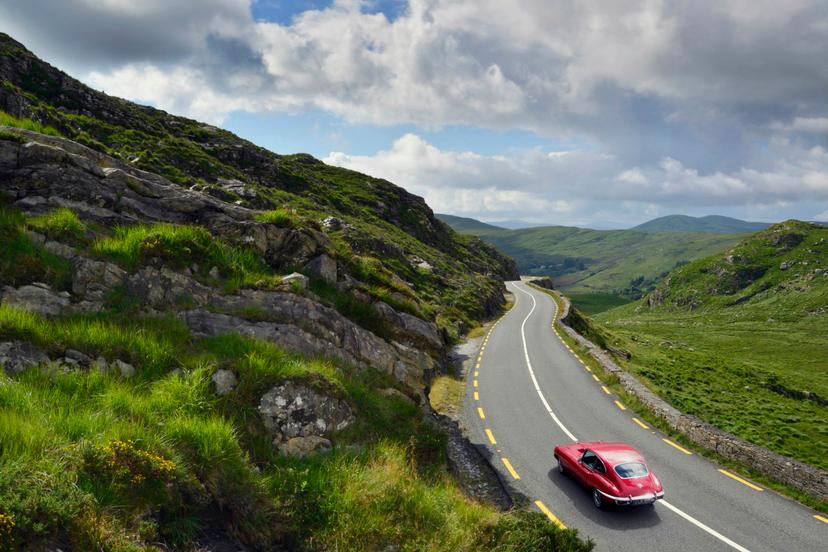 E-Type Jaguar driving on country road between Kenmare and Killarney.
