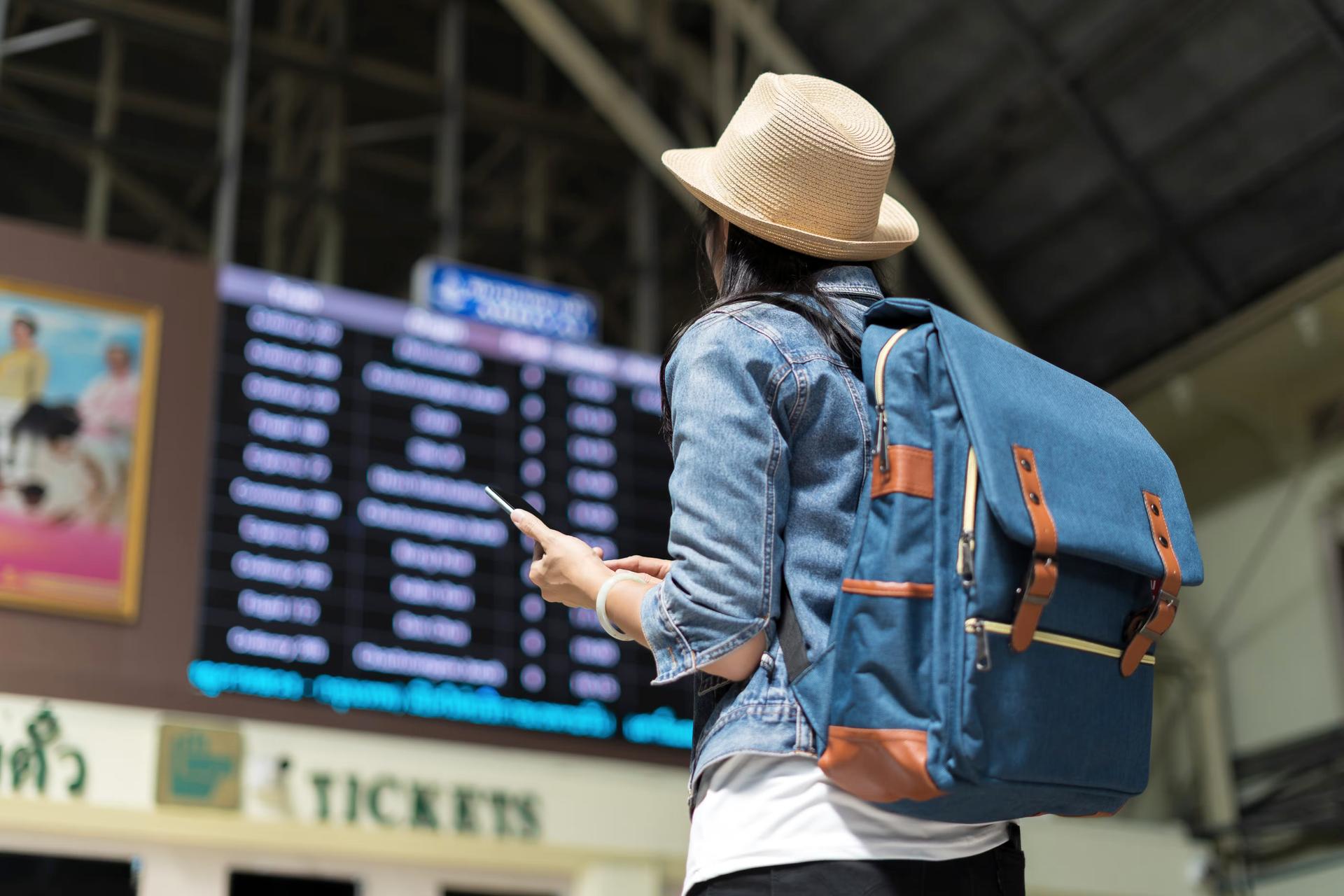 Young woman checking travel timetable board