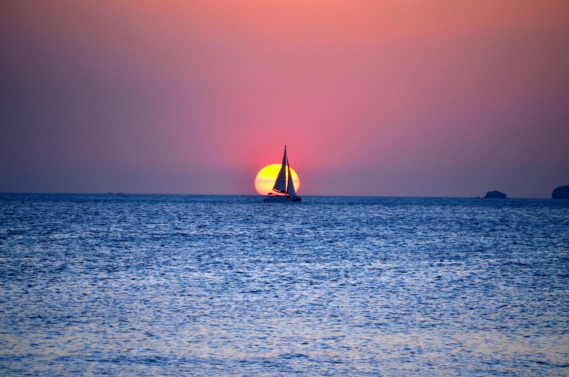 Sunset with sail boat at the ocean