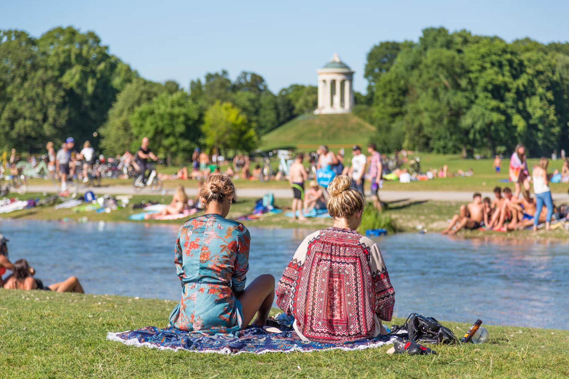 Twee meisjes zitten op een kleed in de Englischer Garten
