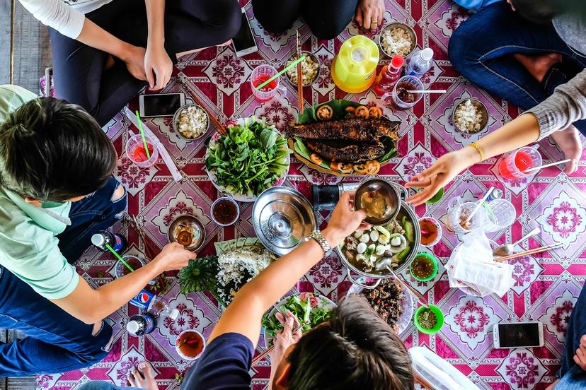 DONG THAP / VIETNAM, 30 DECEMBER 2017 - Top view of happy friends at picnic on countryside outdoor , having lunch with traditional foods.