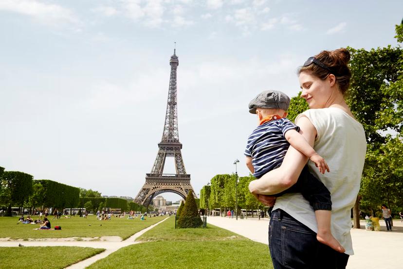 Mother and baby in front of the Eiffel Tower in Paris.