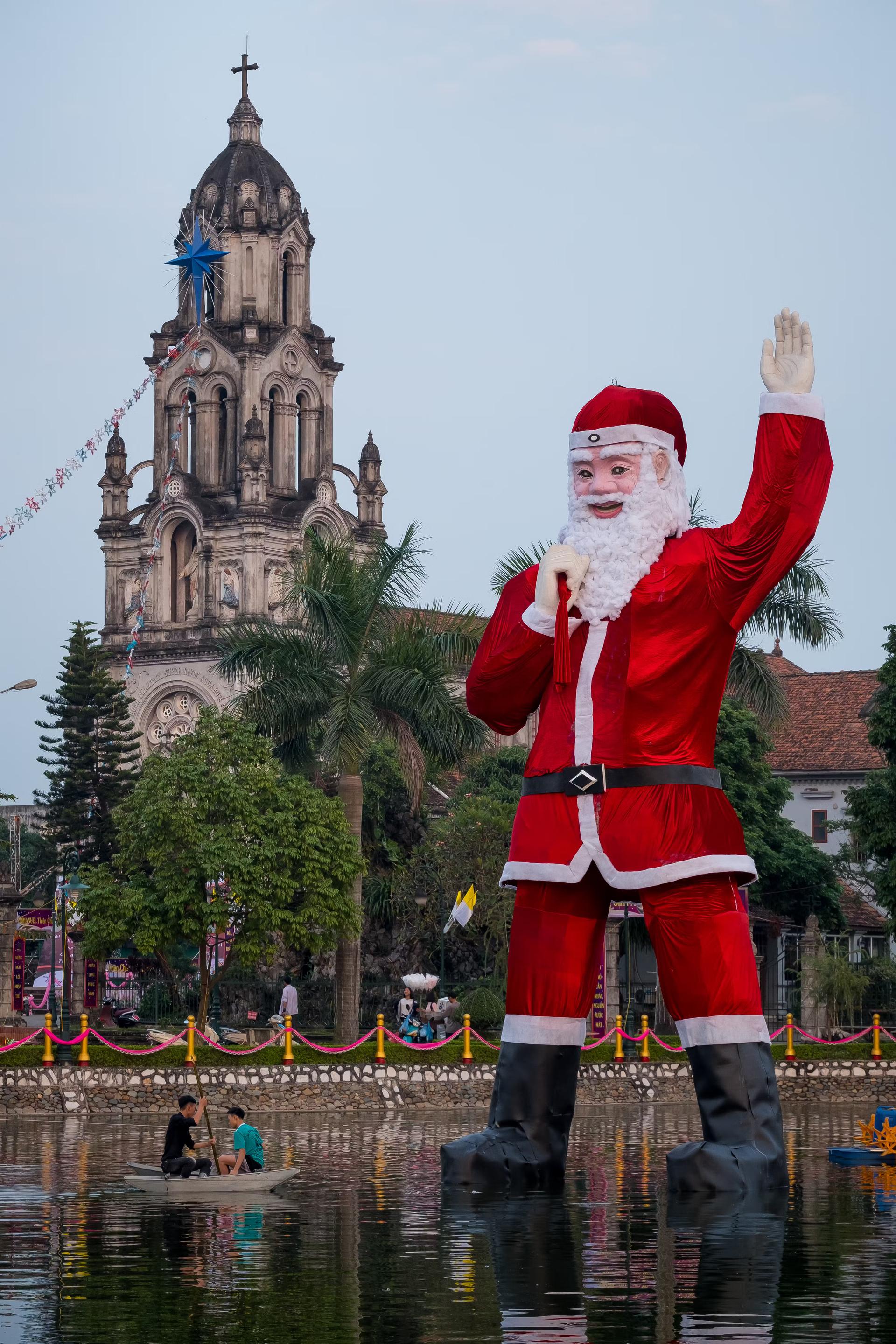   En gigantisk, flytande jultomte står i sjön framför Phu My Cathedral i Hanoi, Vietnam.
