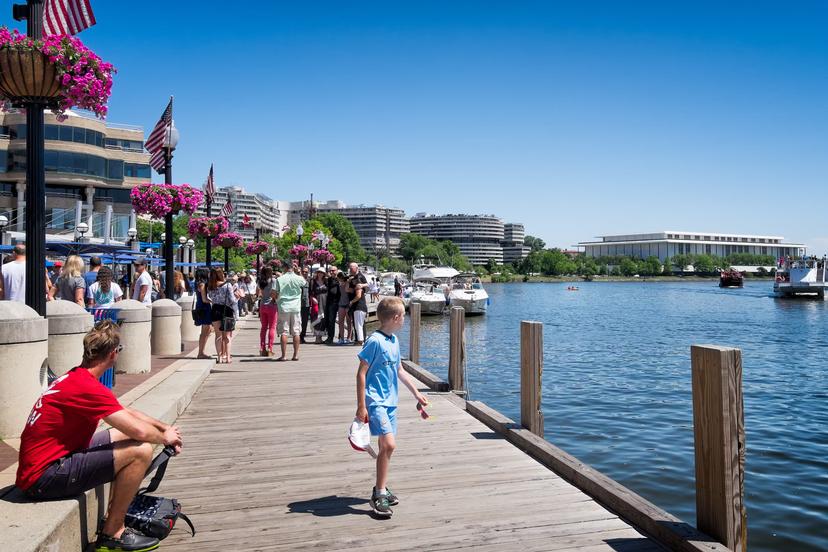 May 24, 2015: Georgetown waterfront dock crowded with people. The Kennedy Center and Watergate complex in the background.