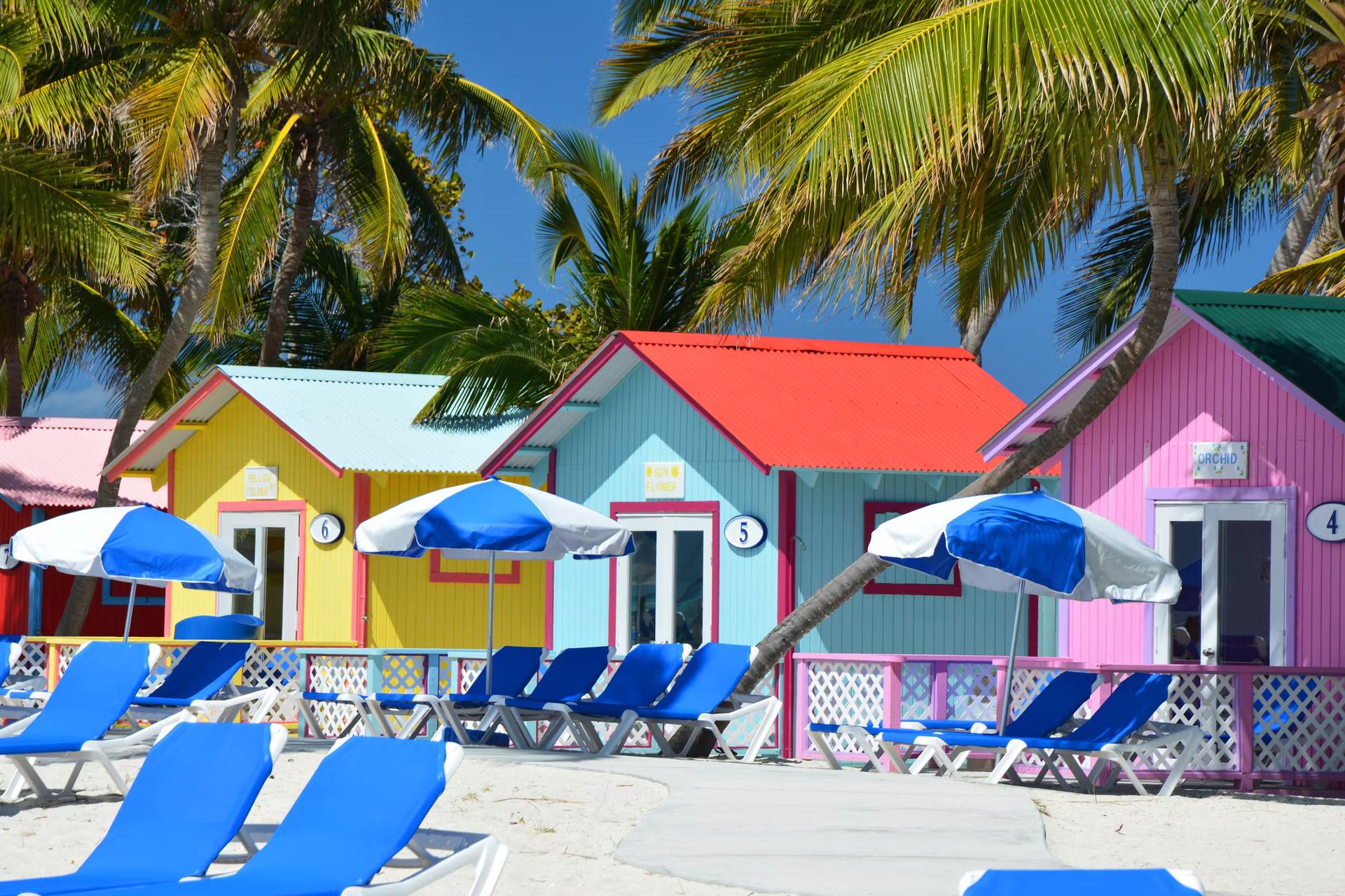 Colorful bungalows and lounge chairs on Princess Cays beach, Eleuthera, Bahamas
