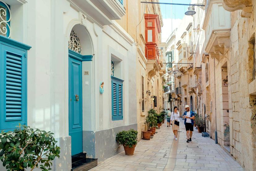 Birgu, Malta: Tourists walking down narrow streets with wooden doors and historical houses on 28 September, 2019. Birgu, also known as Vittoriosa has population near 4,000