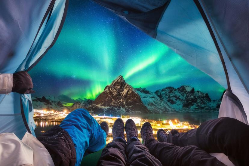 Group of climber are inside camping with aurora borealis over mountain at Sakrisoy village