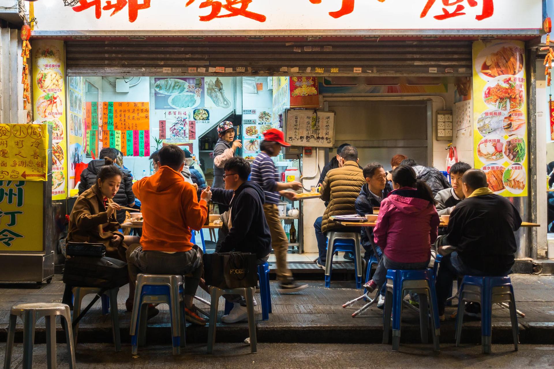 People eating in a street side cafe in Hong Kong