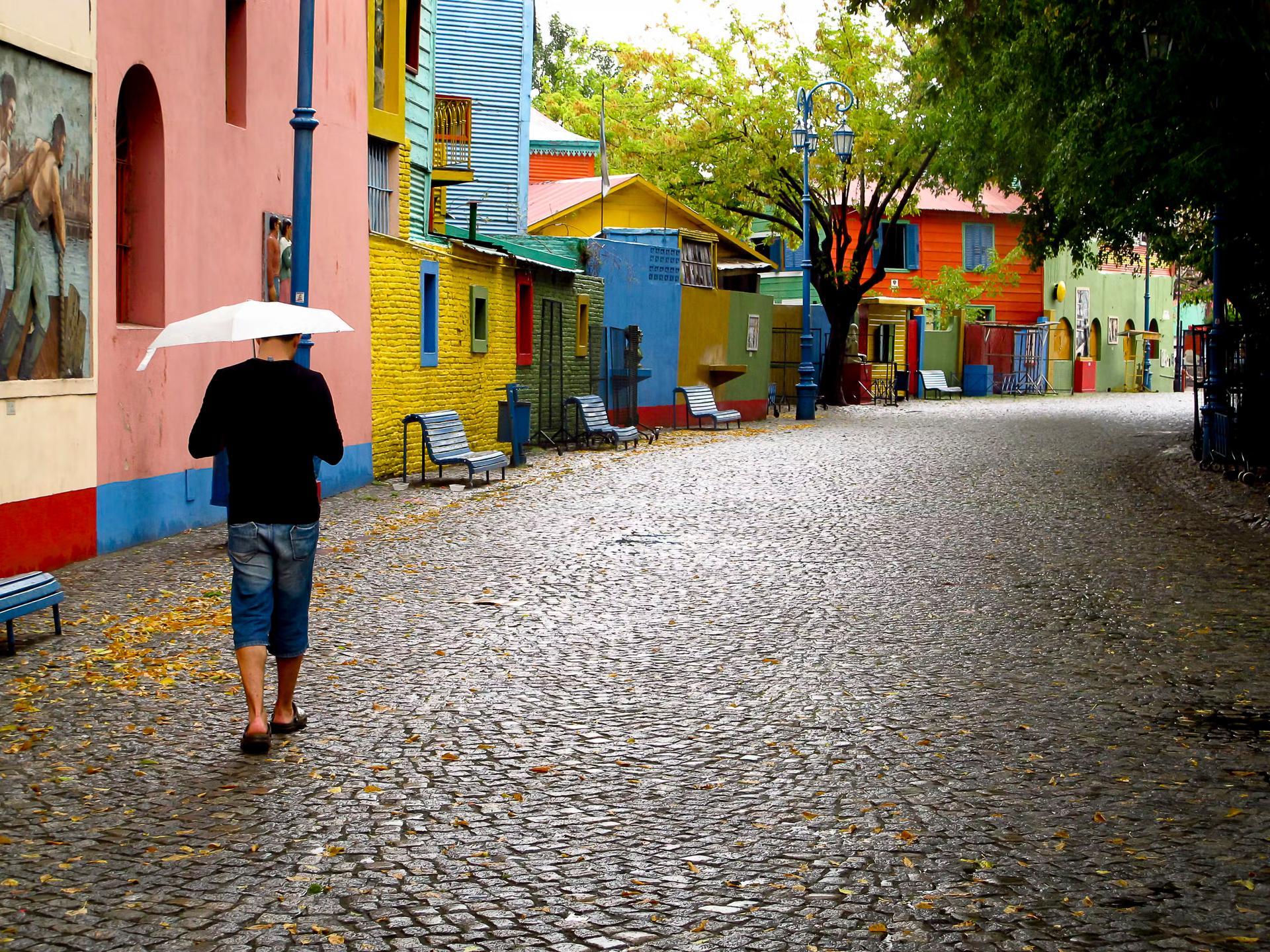 Man går i regnet på de färgglada gatorna i Buenos Aires