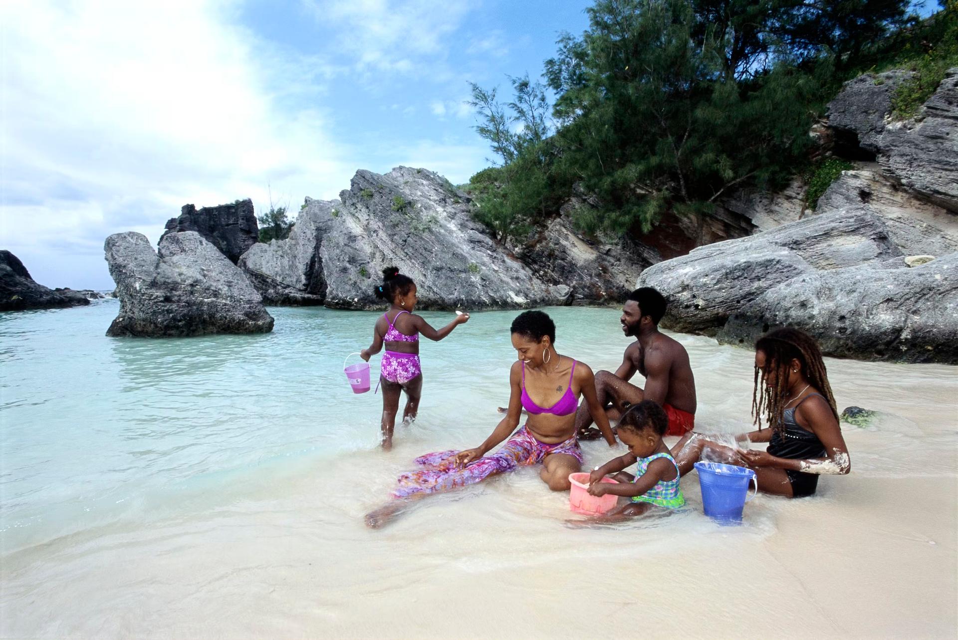 En familj med barn som kopplar av på en Bermuda-strand