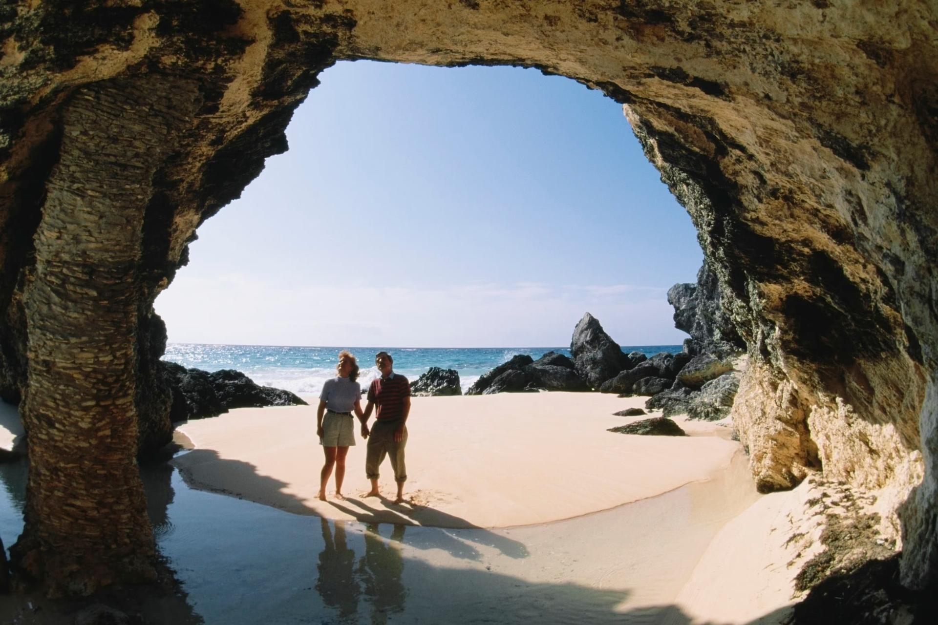 Ett par som observerar stenar nära havet, Natural arch, Bermuda