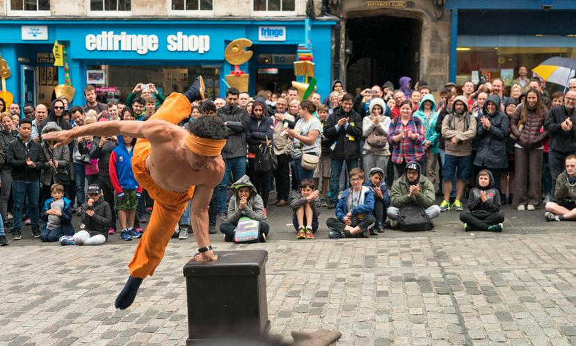 A street performer entertaining spectators on the Royal Mile during the Edinburgh Festival Fringe.