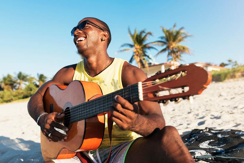 A Cuban man playing guitar on the beach