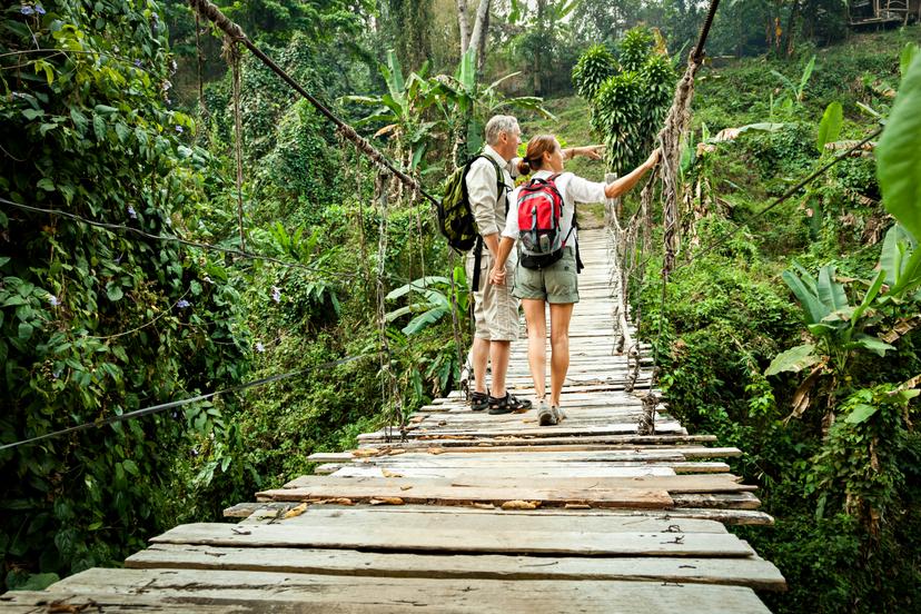Couple with backpack hiking in rainforest