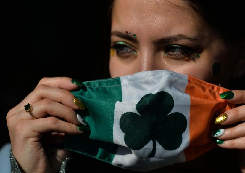 A young woman with fingernails decorated for St. Patrick's puts a face mask outside the Irish Potato Cake Company restaurant in Dublin's city center  on St. Patrick's Day. .On Wednesday, 17 March 2021, in Dublin, Ireland. (Photo by Artur Widak/NurPhoto via Getty Images)