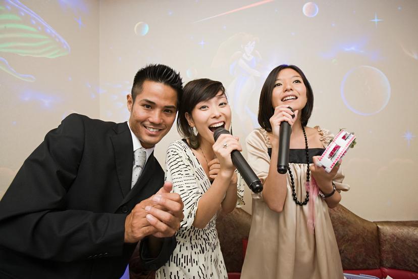 Three friends singing karaoke.