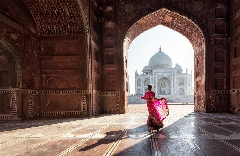 Woman in red saree/sari in the Taj Mahal, Agra, Uttar Pradesh, India; Shutterstock ID 1036002985; your: Claire Naylor; gl: 65050; netsuite: Online ed; full: Taj Mahal intro