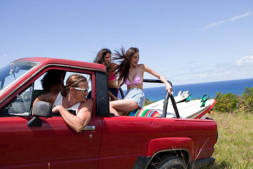Four people in a red truck drive off road in Puerto Rico. 