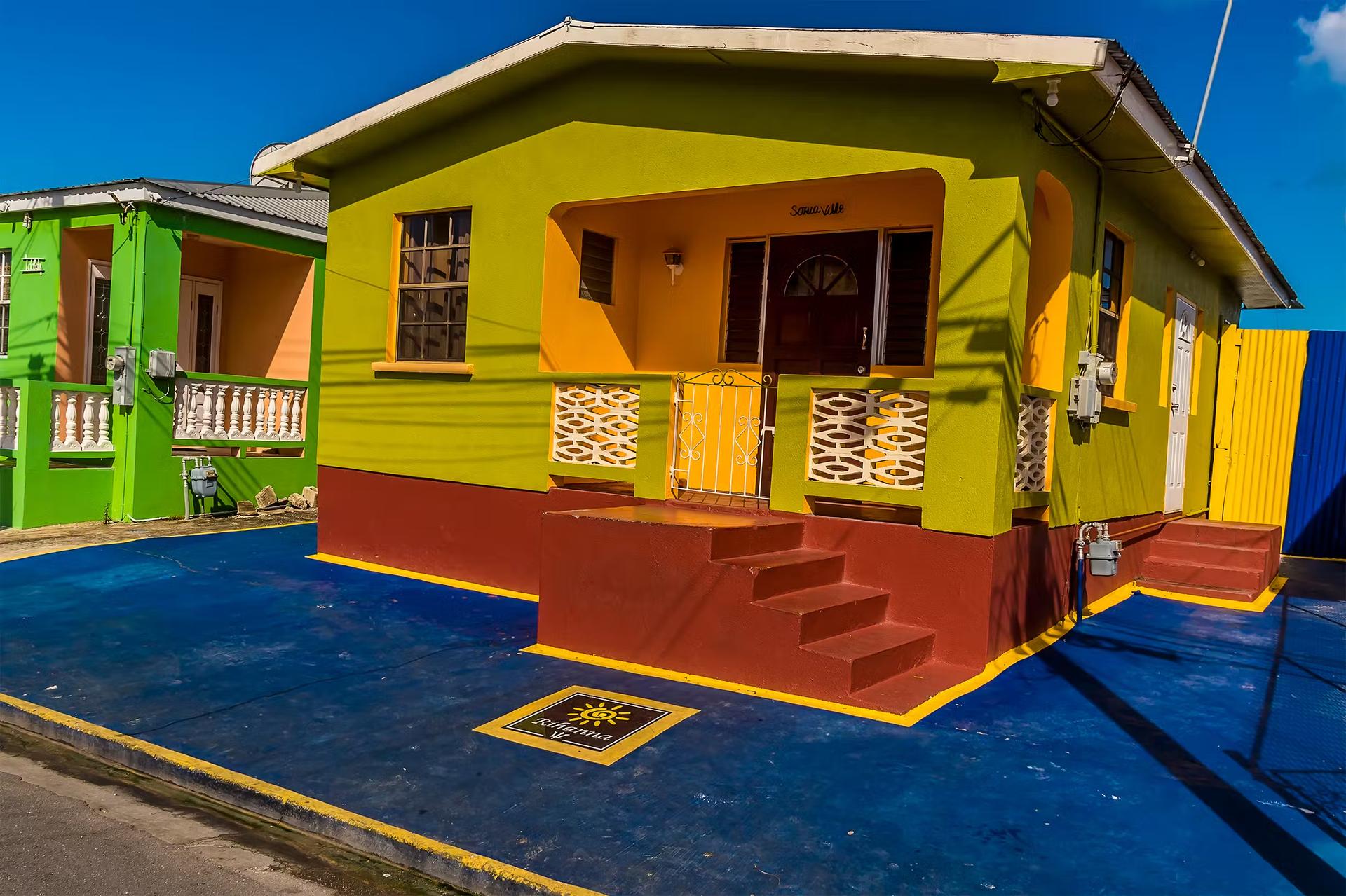 Exteriörbild av det flerfärgade huset till den internationella popstjärnan Rihannas barndomshem på Barbados. 