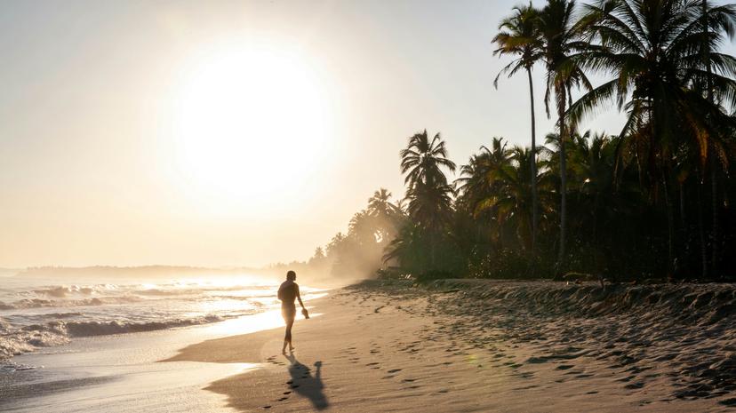 A woman walking at sunrise on the Caribbean Coast of Colombia