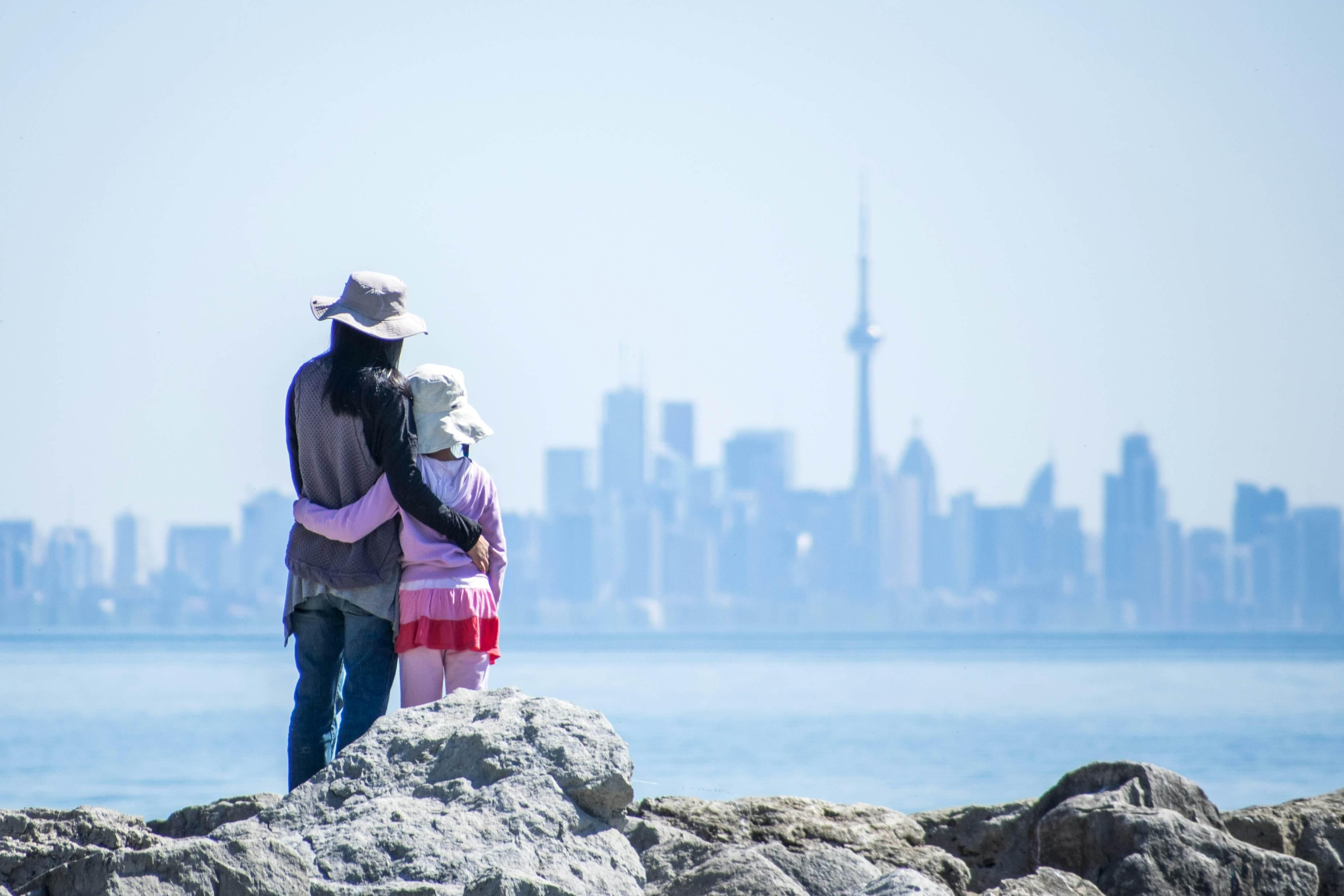 A mother and daughter look out at the Toronto skyline