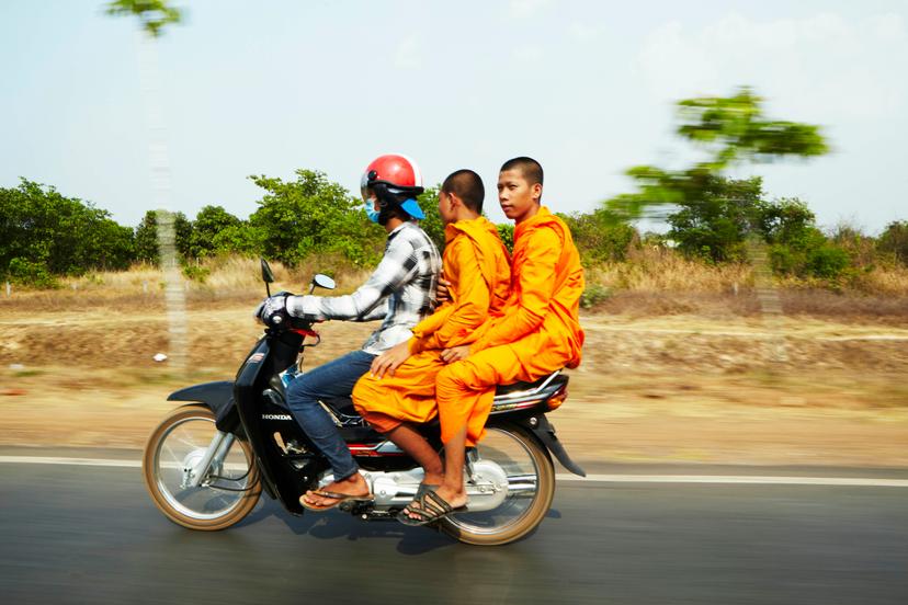 Monks riding on motorcycle.