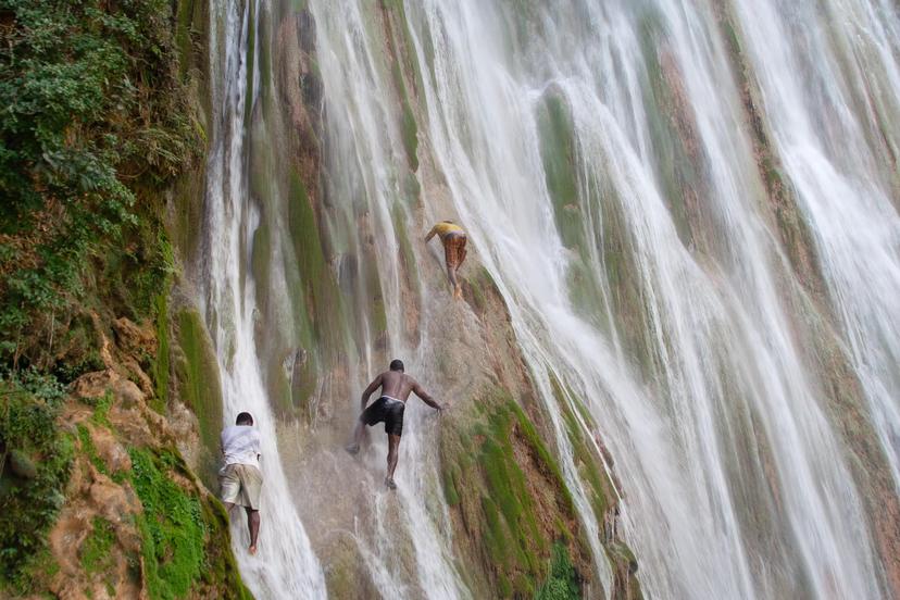 NOVEMBER 24, 2011: Young men climb the steep face of El Limón waterfall.