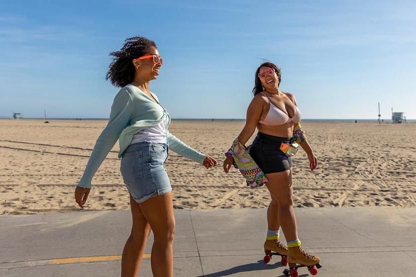 Friends rollerskating along the beach in Los Angeles.