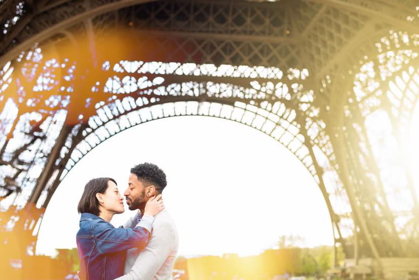 Multi-racial love in Paris - Chinese and African origins. Romantic sunset moment at the Eiffel Tower, Paris, France.