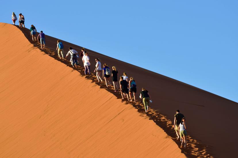 SOSSUSVLEI, NAMIBIA - JAN 29, 2016: Tourists climb Dune No.45 in a year that was declared as a drought year by the government in Namibia, Africa; Shutterstock ID 375359188; your: Sloane Tucker; gl: 65050; netsuite: Online Editorial; full: Namibia National Parks Article