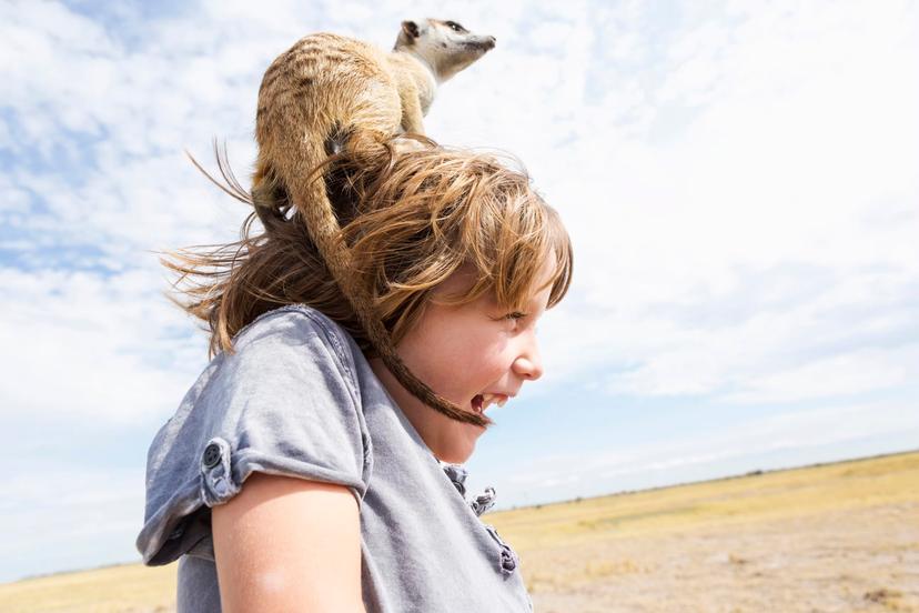 Five year old boy with Meerkat on his head, Kalahari Desert, Makgadikgadi Salt Pans, Botswana