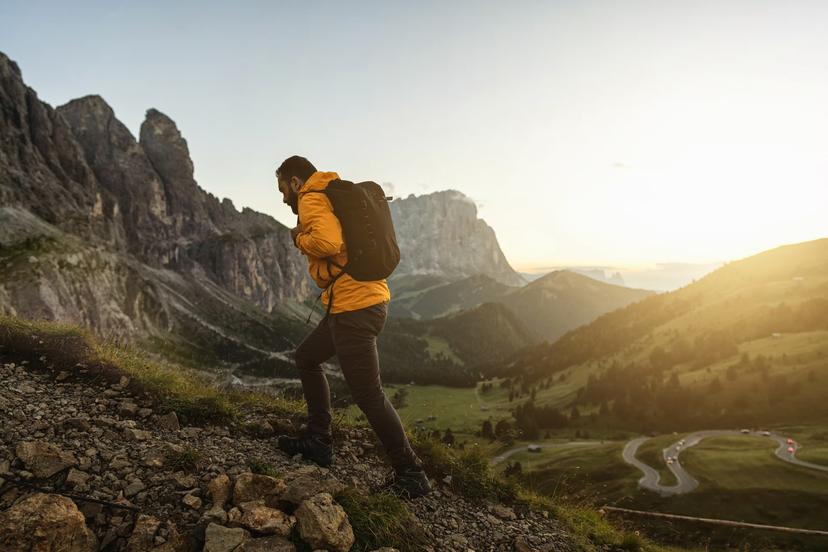 Man mountain hiking at sunset on the Dolomites: post pandemic outdoor adventure