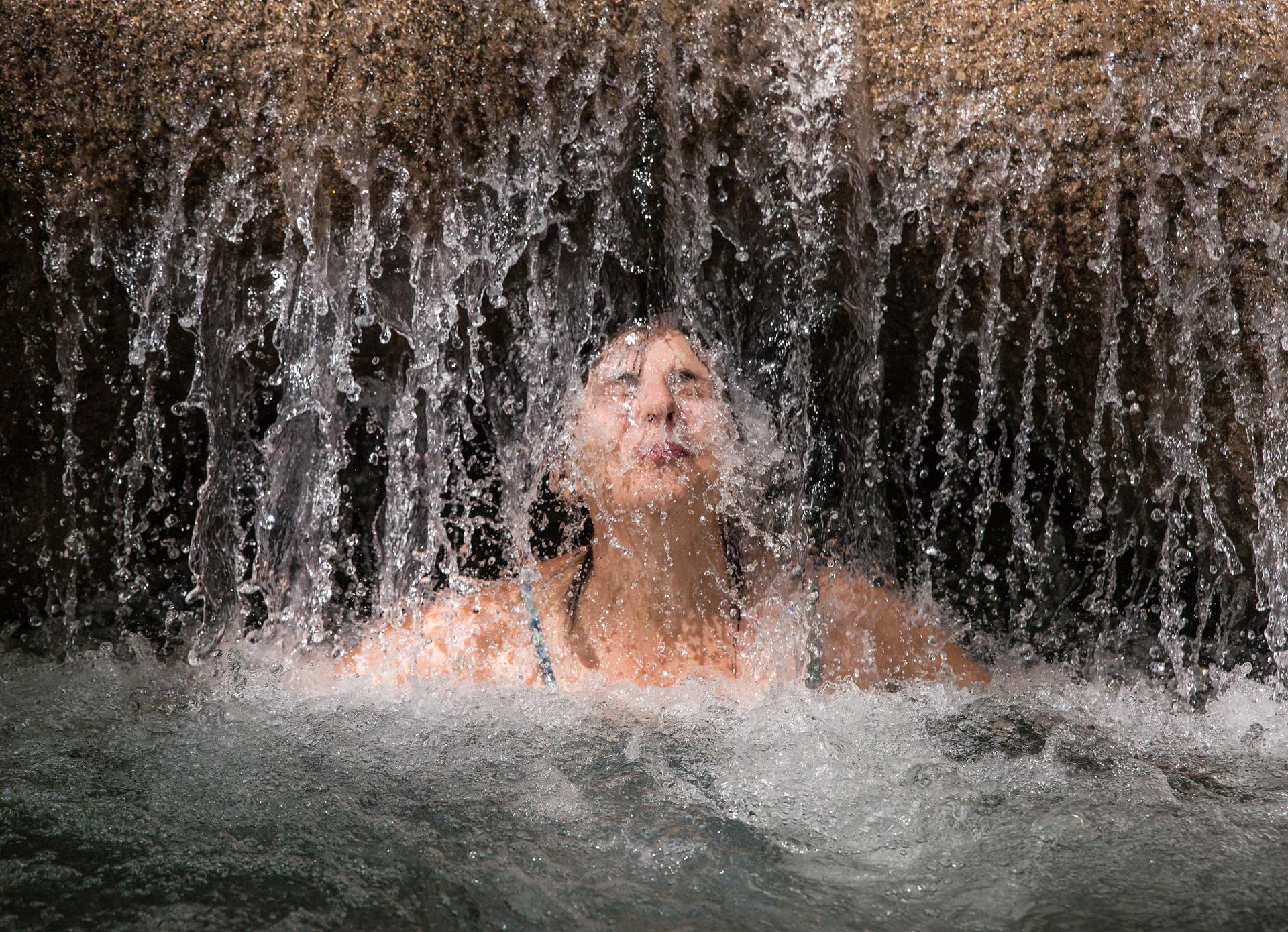 Kvinnan njuter av en uppfriskande vattenmassage i Mayfield Falls, Glenbrook, Jamaica