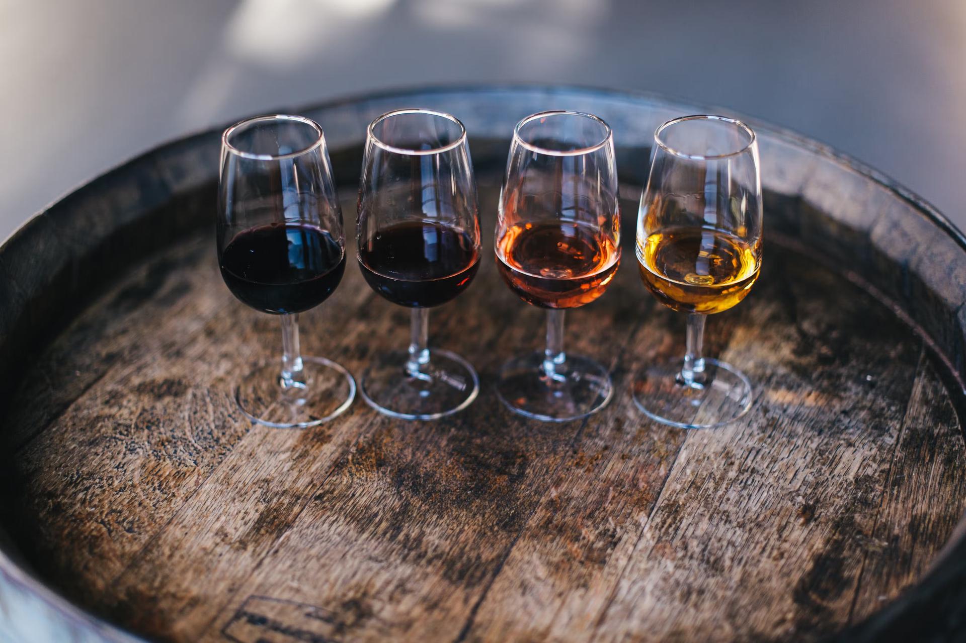 Fyra olika typer av portvin producerade i Porto, Portugal, i glas på en trätunna