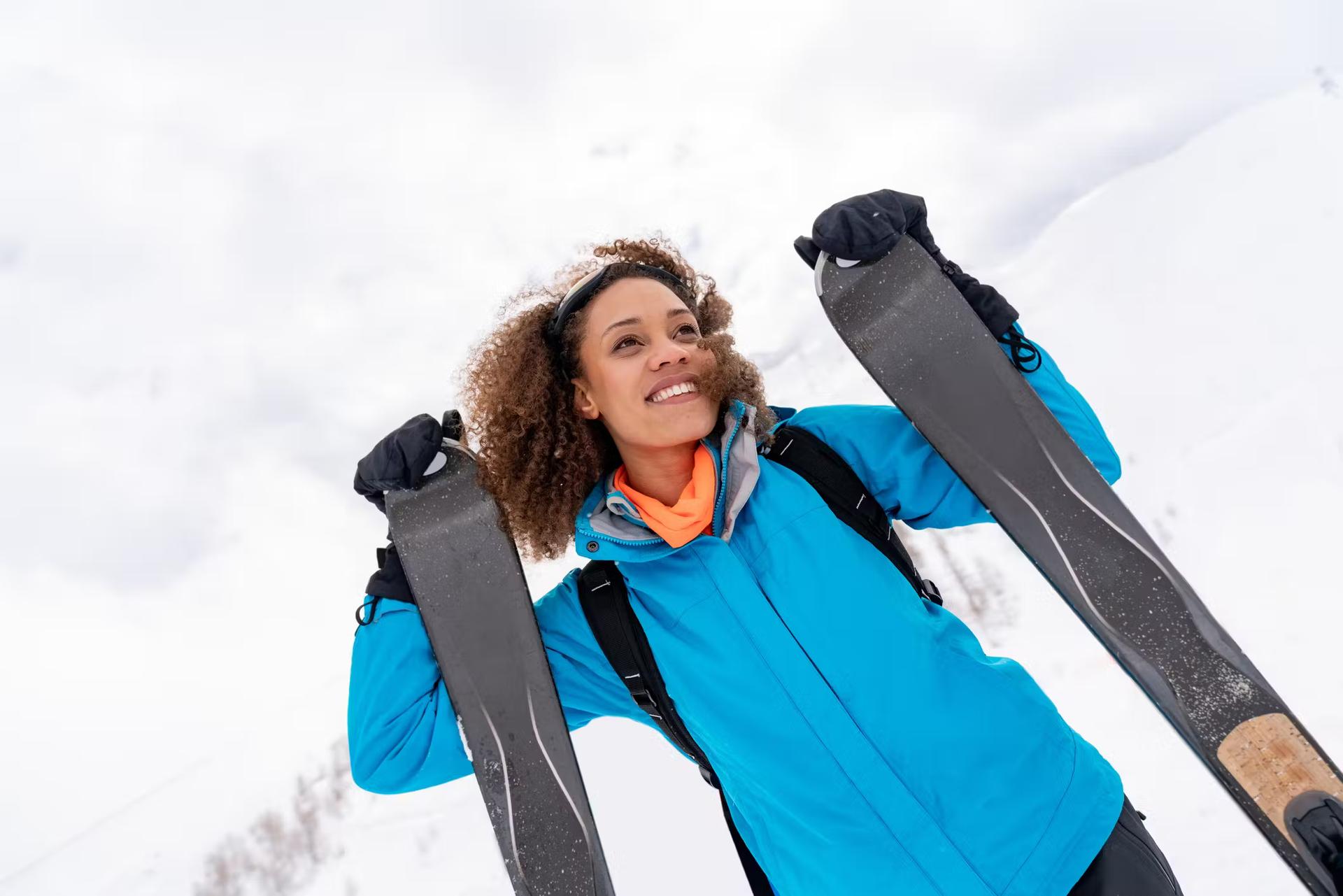 Portrait of a beautiful African American woman skiing and looking very happy outdoors