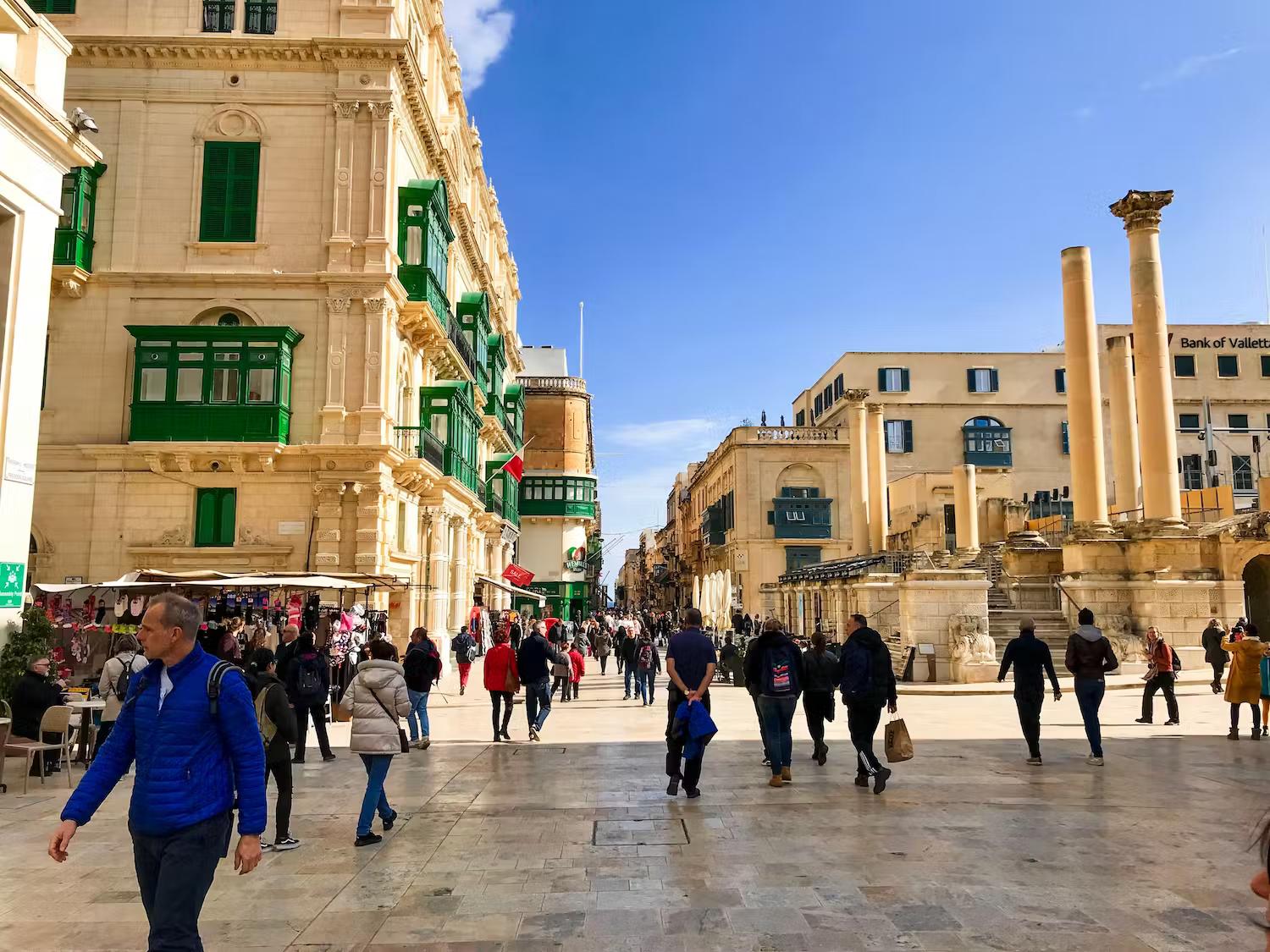People walk around central Valletta on a sunny winter morning, Valletta, Malta