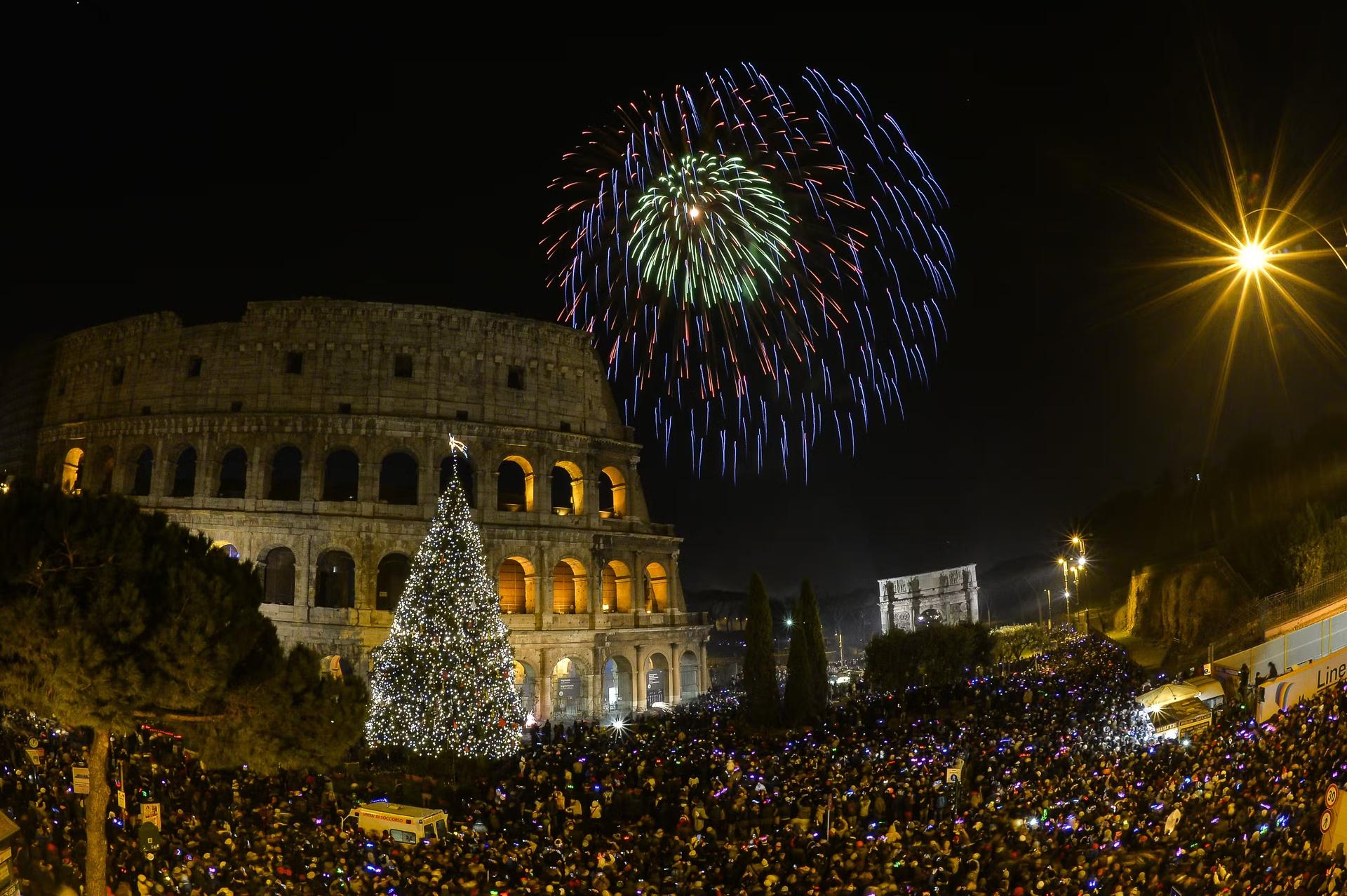 People cheer in front of Rome's ancient Colosseum as fireworks explode to celebrate the new year 