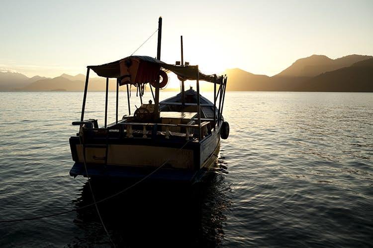 A boat explores the Bay of Kings near Ilha Grande at sunrise. Image by LiciaR / Vetta / Getty Images