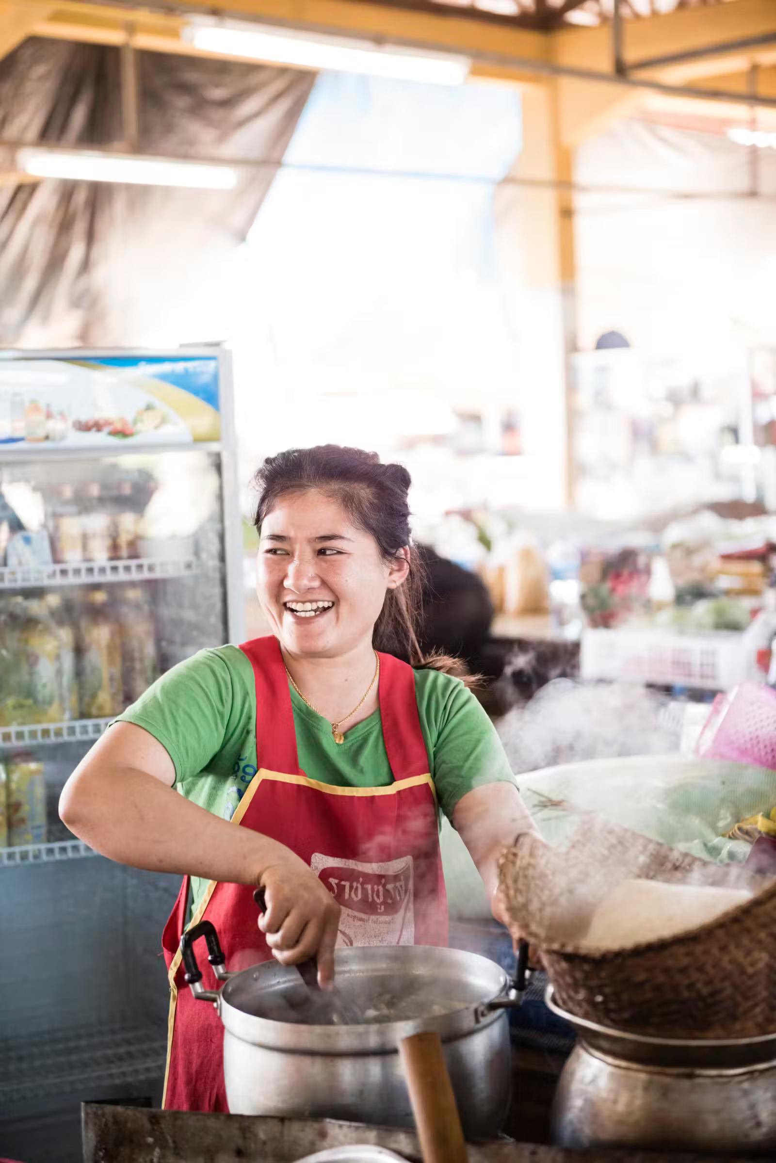 Mrs Nang serves her speciality, khao poon, or noodle soup, in the market at Paksong 