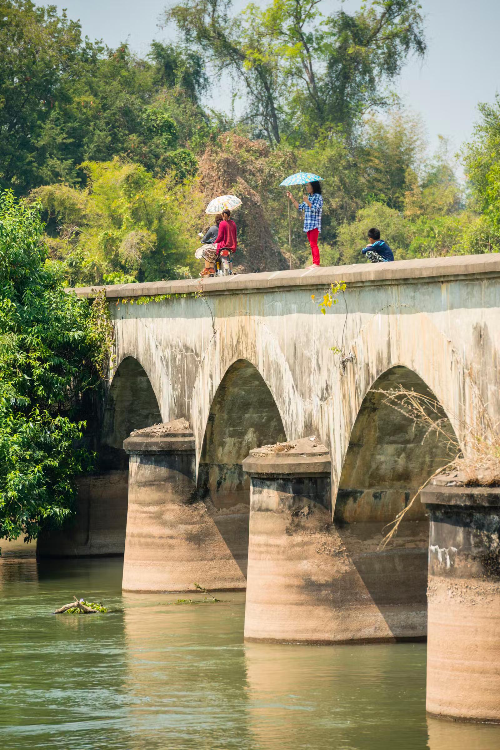 Locals cross the bridge between the islands of Don Det and Don Khon 