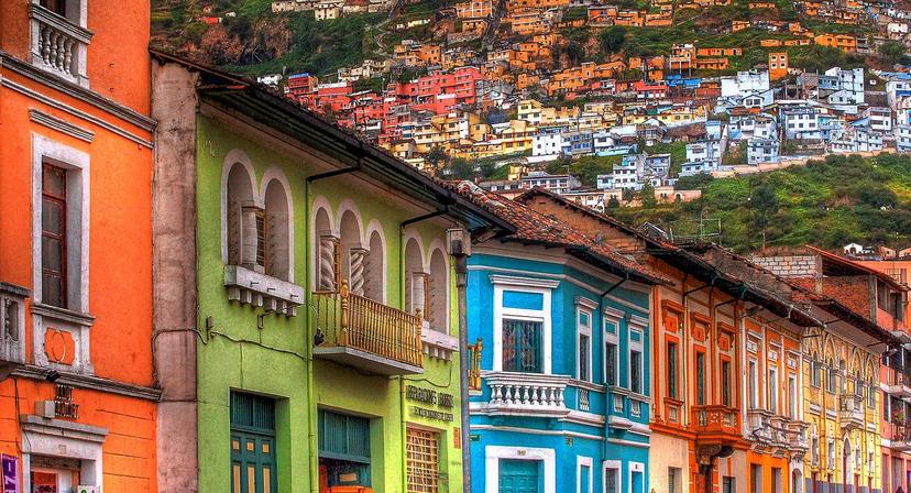 A row of multicolored houses against the backdrop of houses on a hillside in Quito © Mike Matthews Photography / Getty Images