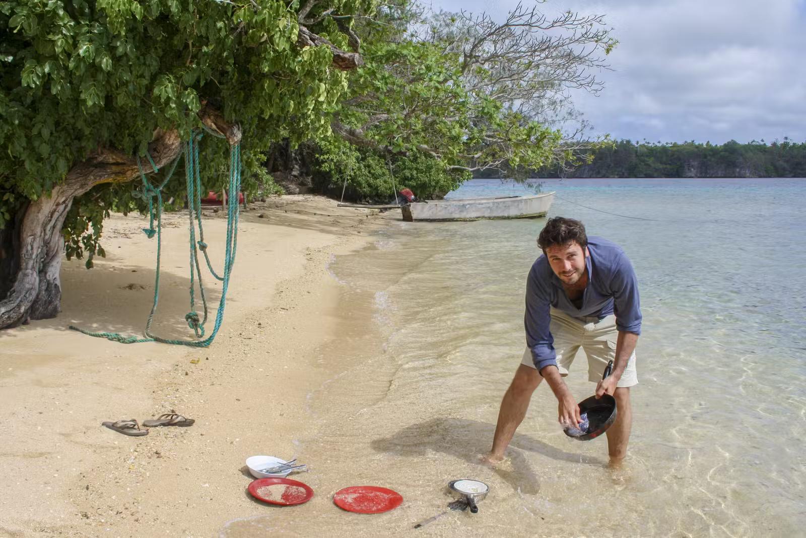Peter Watson washing dishes in the sea in Fiji © Atlas and Boots