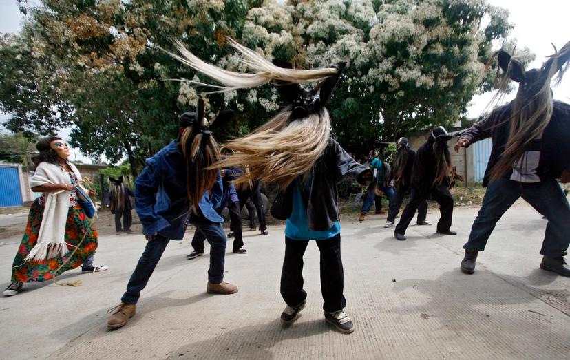 Three men in masks with long beards swing the hair around