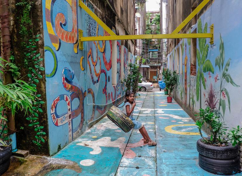 A girl plays on a swing in one of the renovated back alleys. Photo by: Dominic Horner