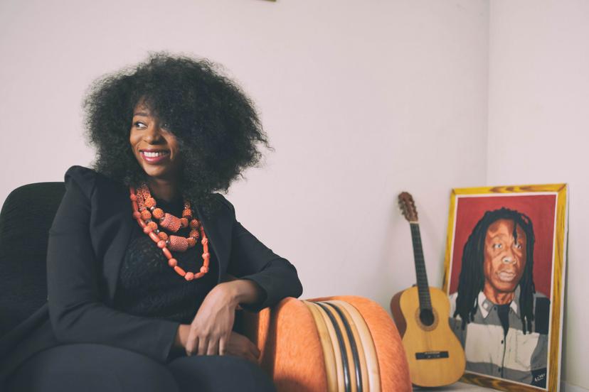 Adiouza, whose melodic pop is influenced by roots music, in her sitting room, with a portrait of her father, the musician Ousmane Diallo, alias Ouza © Emmanuelle Andrianjafy / Lonely Planet