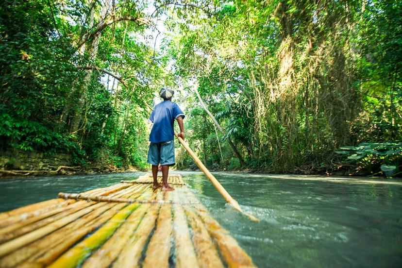 A man river rafting in the forest of Jamaica. 